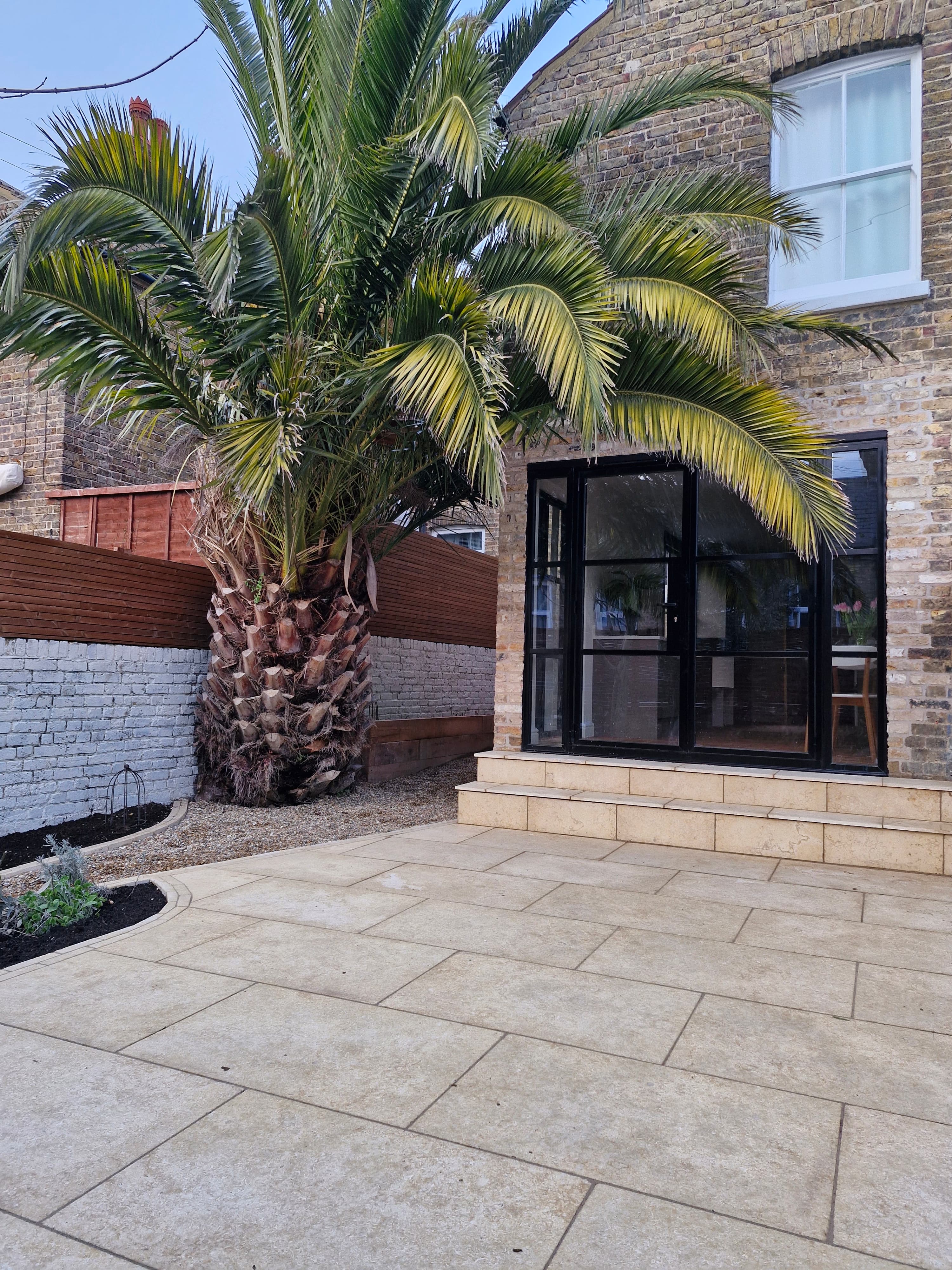 Palm tree garden with stone paving and timber decking
