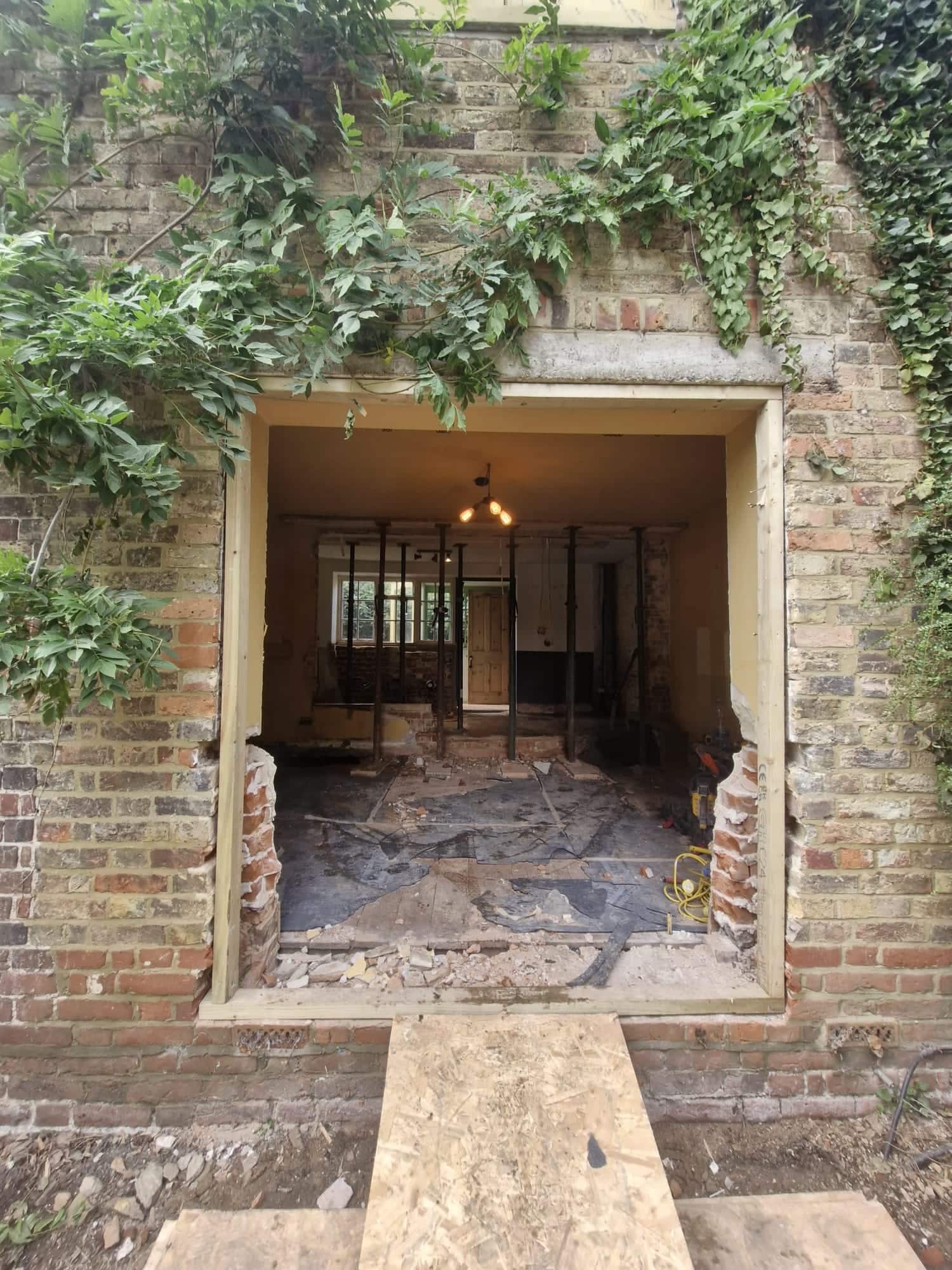 New structural opening cut through the brick rear wall of a period house during an extension build