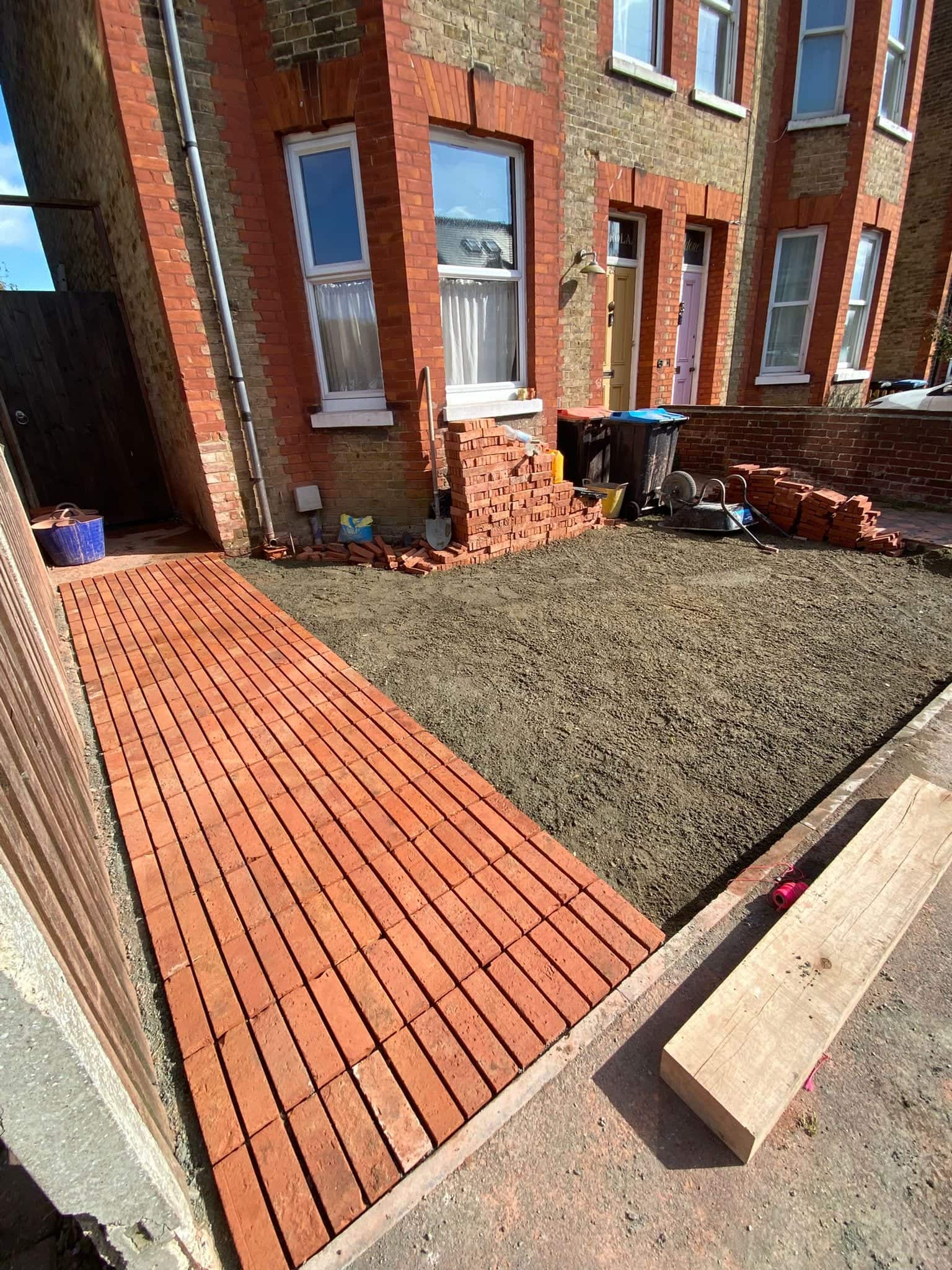Front garden driveway in progress with a first run of clay pavers laid and the sub-base screeded ready for the rest