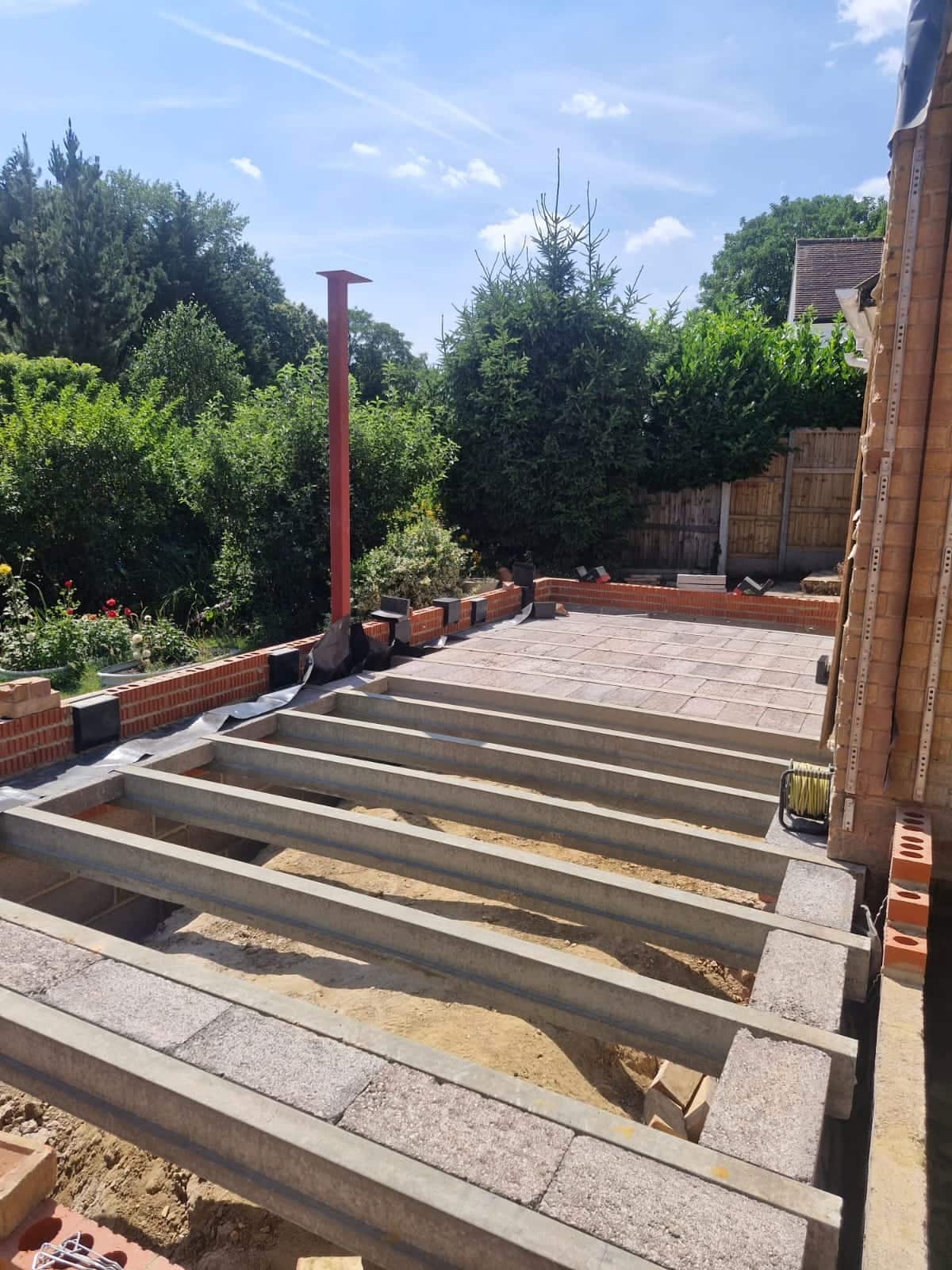 Beam-and-block floor and new brickwork for a rear extension during construction, with a steel column in place