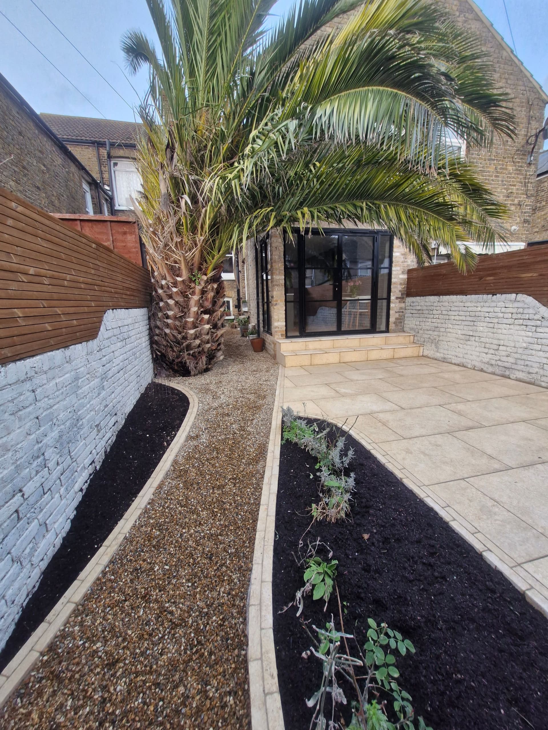 Stone wall and timber decking pathway